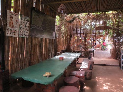 a room with a green table and chairs and trees at Ratanakiri Homestay & Jungle Trek in Banlung