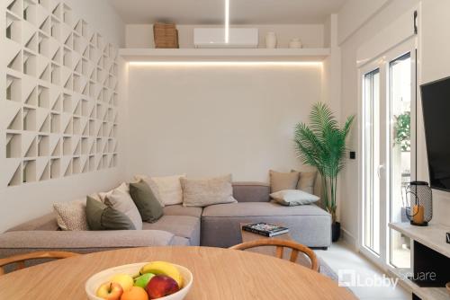sala de estar con sofá y mesa con un bol de fruta en Muse Apartment by LobbySquare, en Atenas