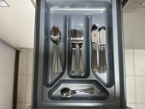 a metal tray with utensils in a kitchen sink at Lujoso Loft La Moraleja in Madrid