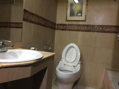 a bathroom with a toilet and a sink at Hotel City Inn in Chittagong