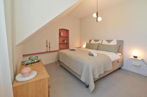 a bedroom with a large bed and a table at Style pur: Designer-Wohnung in Top-Lage! in Wittlich