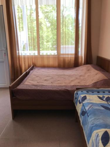 - une chambre avec un lit et une grande fenêtre dans l'établissement Hotel Nino Ureki, à Ureki