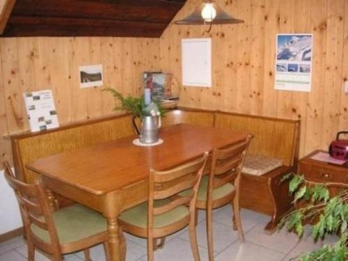 uma sala de jantar com uma mesa de madeira e cadeiras em Bauernhof Bättwil - b48307 em Burgdorf