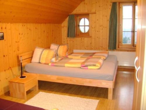 a bedroom with a bed in a wooden cabin at Bauernhof Bättwil - b48307 in Burgdorf