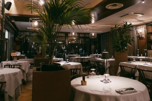 a restaurant with white tables and chairs and plants at Quel Castello di Diegaro in Cesena
