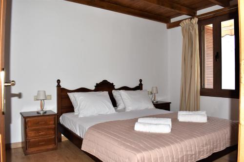 1 dormitorio con 1 cama con 2 toallas en Madaro Traditional House, en Arménoi