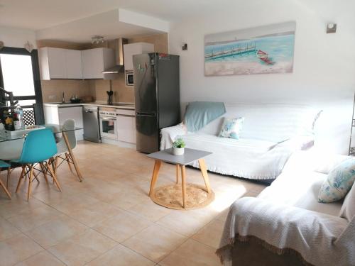 a kitchen and living room with a couch and a table at Apartment by the sea with WIFI & Netflix in El Cotillo