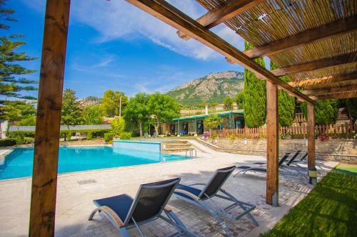 a patio with chairs and a swimming pool at Residenza Giancesare Family Apartments in Paestum