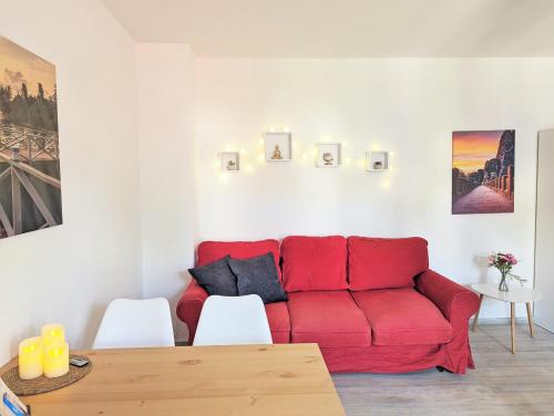 a red couch in a living room with a table at UO3 - Urlaubsmagie- Urlaubsoase mitten in Sebnitz in Sebnitz