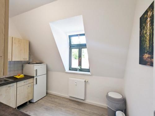 a kitchen with a white refrigerator and a window at UO3 - Urlaubsmagie- Urlaubsoase mitten in Sebnitz in Sebnitz