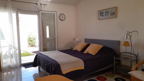 une chambre avec un lit et une horloge au mur dans l'établissement Atlantic Residence Studios, à Jonzac