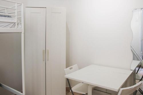 Habitación con armario blanco y escritorio blanco. en Bright studio located near Paris en Pantin