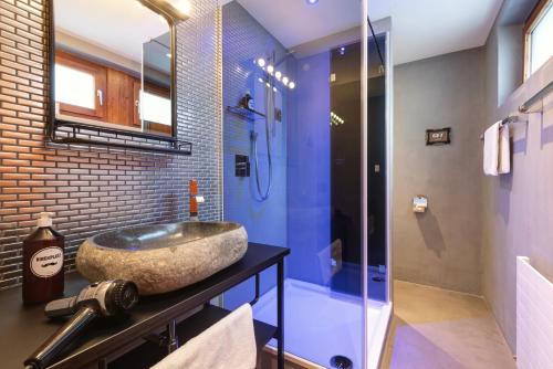 a bathroom with a sink and a glass shower at Hotel Pension Kirchplatz in Sankt Anton am Arlberg