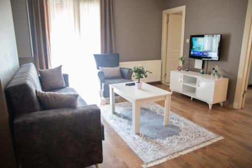 a living room with a couch and a table and a tv at The Hera Hotels in Istanbul