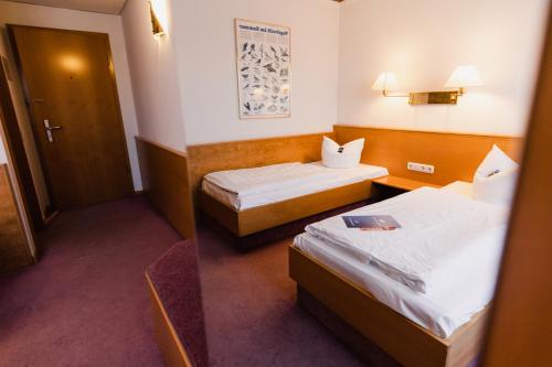 ein Hotelzimmer mit 2 Betten und einem Spiegel in der Unterkunft Hotel Bavaria Brehna in Brehna