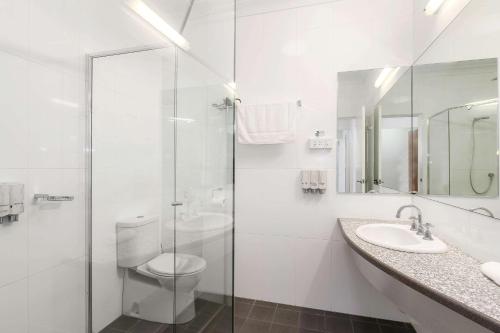 La salle de bains blanche est pourvue de toilettes et d'un lavabo. dans l'établissement Quality Inn Grafton, à Grafton