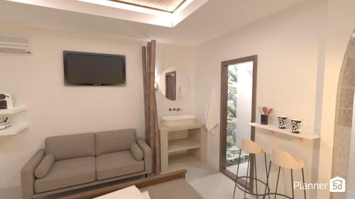 a living room with a couch and a tv on the wall at Alykes Studios & Suites in Agios Prokopios