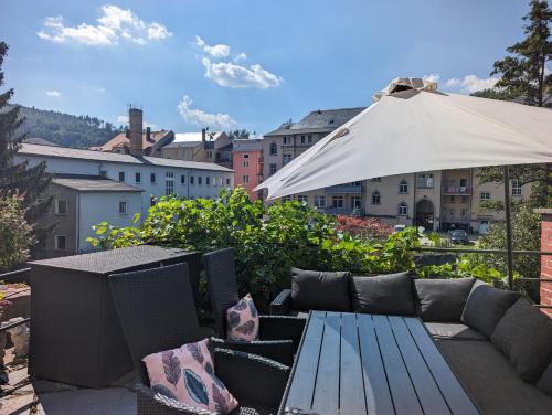 a patio with a couch and an umbrella at UO3 - Urlaubsmagie- Urlaubsoase mitten in Sebnitz in Sebnitz