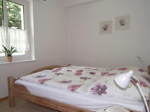 um quarto com uma cama com flores cor-de-rosa em Ferienwohnung Nexö, 30 qm, ein Schlafzimmer N1 em Ilsenburg
