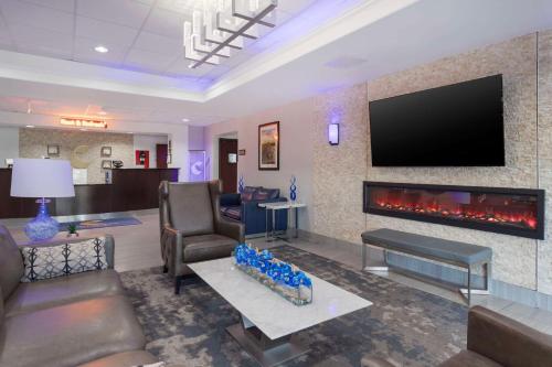 a living room with a fireplace and a flat screen tv at Comfort Inn by Choice Hotels Orange, TX in Orange