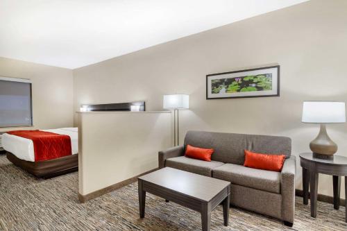 a hotel room with a couch and a bed at Comfort Inn by Choice Hotels Orange, TX in Orange