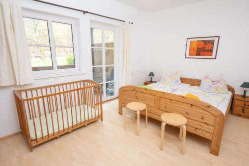 - une chambre avec un lit bébé, un lit et deux chaises dans l'établissement Ferienwohnung Nexö, 85 qm, 3 Schlafzimmer N2, à Ilsenburg