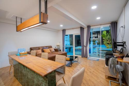 een woonkamer met een tafel en een bank bij Bayside 19 Beachfront Poolvilla in Hua Hin