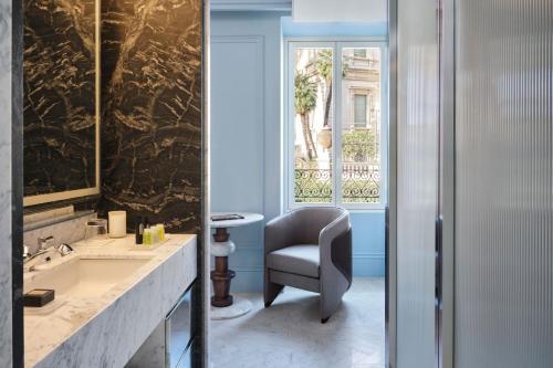 La salle de bains est pourvue d'une chaise et d'un lavabo. dans l'établissement W Rome, à Rome