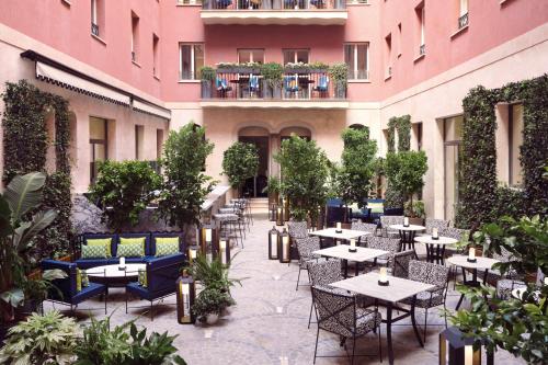 un patio esterno con tavoli e sedie in un edificio di W Rome a Roma