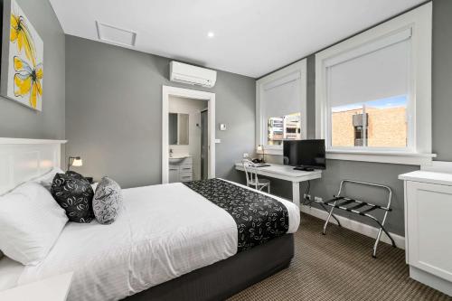 a bedroom with a bed and a desk with a computer at CH Boutique Hotel, Ascend Hotel Collection in Tamworth