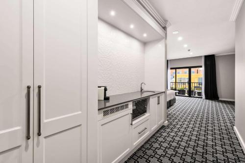 a kitchen with white cabinets and a tile floor at CH Boutique Hotel, Ascend Hotel Collection in Tamworth