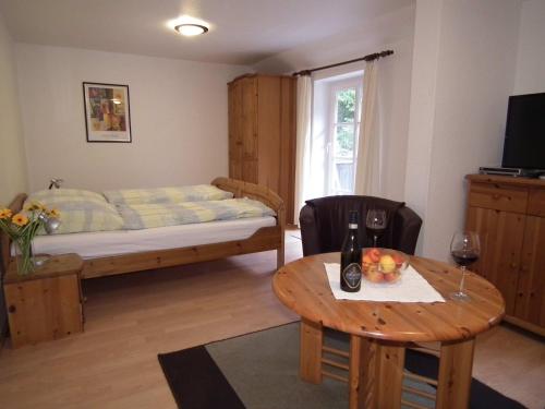 een kamer met een bed en een tafel met wijnglazen bij Ferienwohnung Nexö 25 qm, 1 Wohn-Schlafzimmer N7 in Ilsenburg