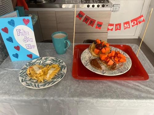 two plates of food on a table with a cake at Segovia apartment in Bogotá