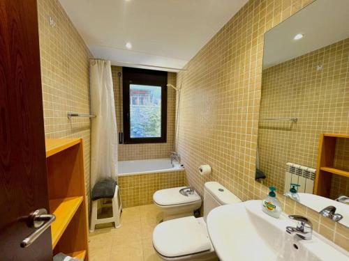een badkamer met een wastafel, een toilet en een spiegel bij 5. APT encantador en Canillo. in Canillo