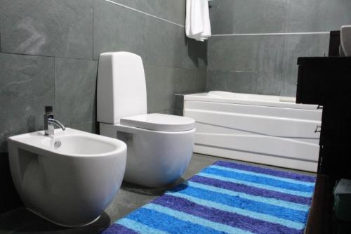 een badkamer met een wastafel, een toilet en een bad bij Casa da Barragem in Marco de Canavezes
