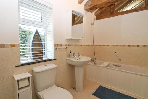 ein Badezimmer mit Toilette, Waschbecken und Badewanne in der Unterkunft Beachside holiday home in Saint Merryn