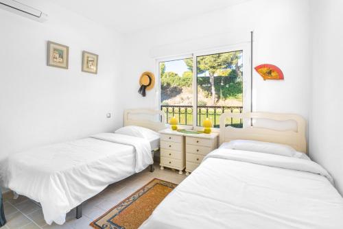 drie bedden in een kamer met een raam bij Miraflores in Mijas Costa