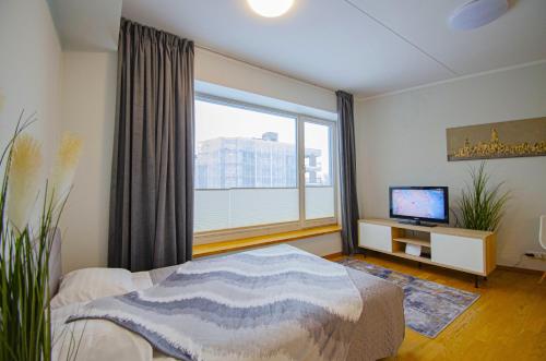 um quarto com uma cama e uma grande janela em Fortune Apartments - City, Contactless em Tartu