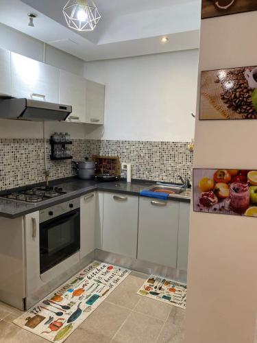 Una cocina con gabinetes blancos y un horno de estufa. en Résidence palmerie, en La Marsa