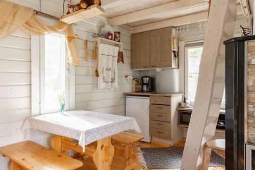 een kleine keuken met een tafel in een tiny house bij Traditional cottage with hot tub in Uurainen