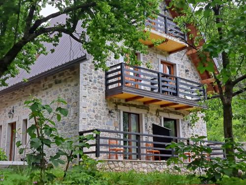 a building with a balcony on the side of it at Villa Gjeçaj Guesthouse and Restaurant in Theth