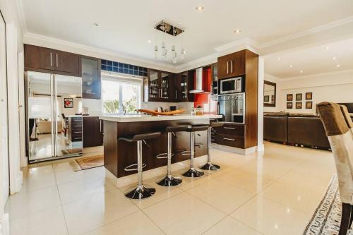 a large kitchen with a island with bar stools at Fifty1 on Long on Kingswood Golf Estate in George