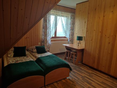 a bedroom with a bed and a desk and a window at Pokoje u Matusa in Gliczarów