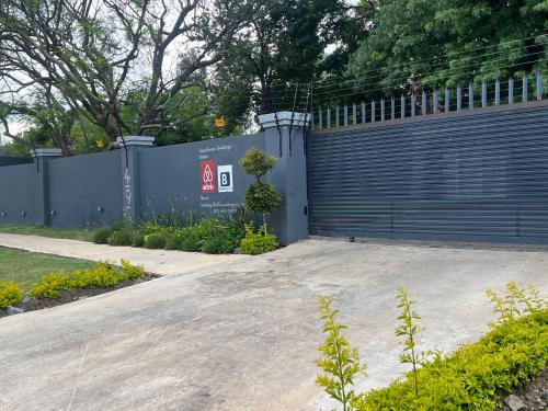 a blue fence with a gate next to a driveway at Ubuntu Lifestyle Estate - Phalaphala DeLux in Krugersdorp