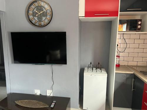 a kitchen with a clock on the wall and a refrigerator at Ubuntu Lifestyle Estate - Phalaphala DeLux in Krugersdorp
