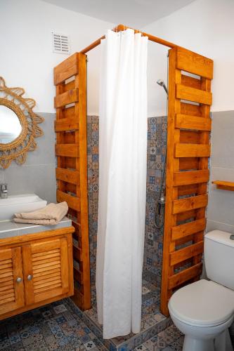 a bathroom with a toilet and a shower curtain at La Maison des Vagues in Sidi Kaouki