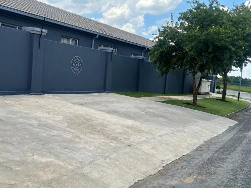 a parking lot in front of a blue building at Ubuntu Lifestyle Estate - Phalaphala DeLux in Krugersdorp