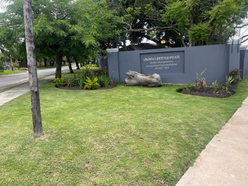 a sign for a park with a tree in the grass at Ubuntu Lifestyle Estate - Phalaphala DeLux in Krugersdorp