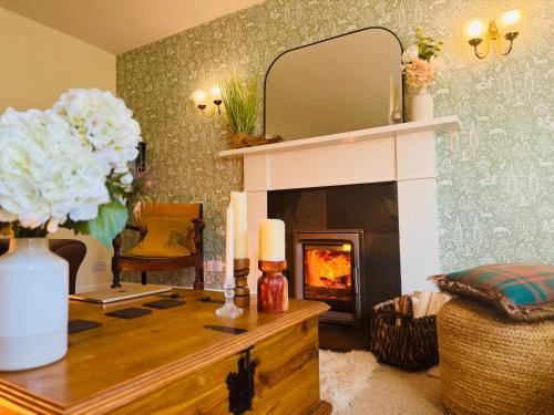 a living room with a fireplace and a mirror at Rosemount Cottage TWO - Highland Cottage in Garve