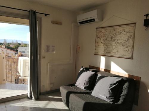 - un salon avec un canapé et une carte murale dans l'établissement studio de la plage, à Saint-Cyprien